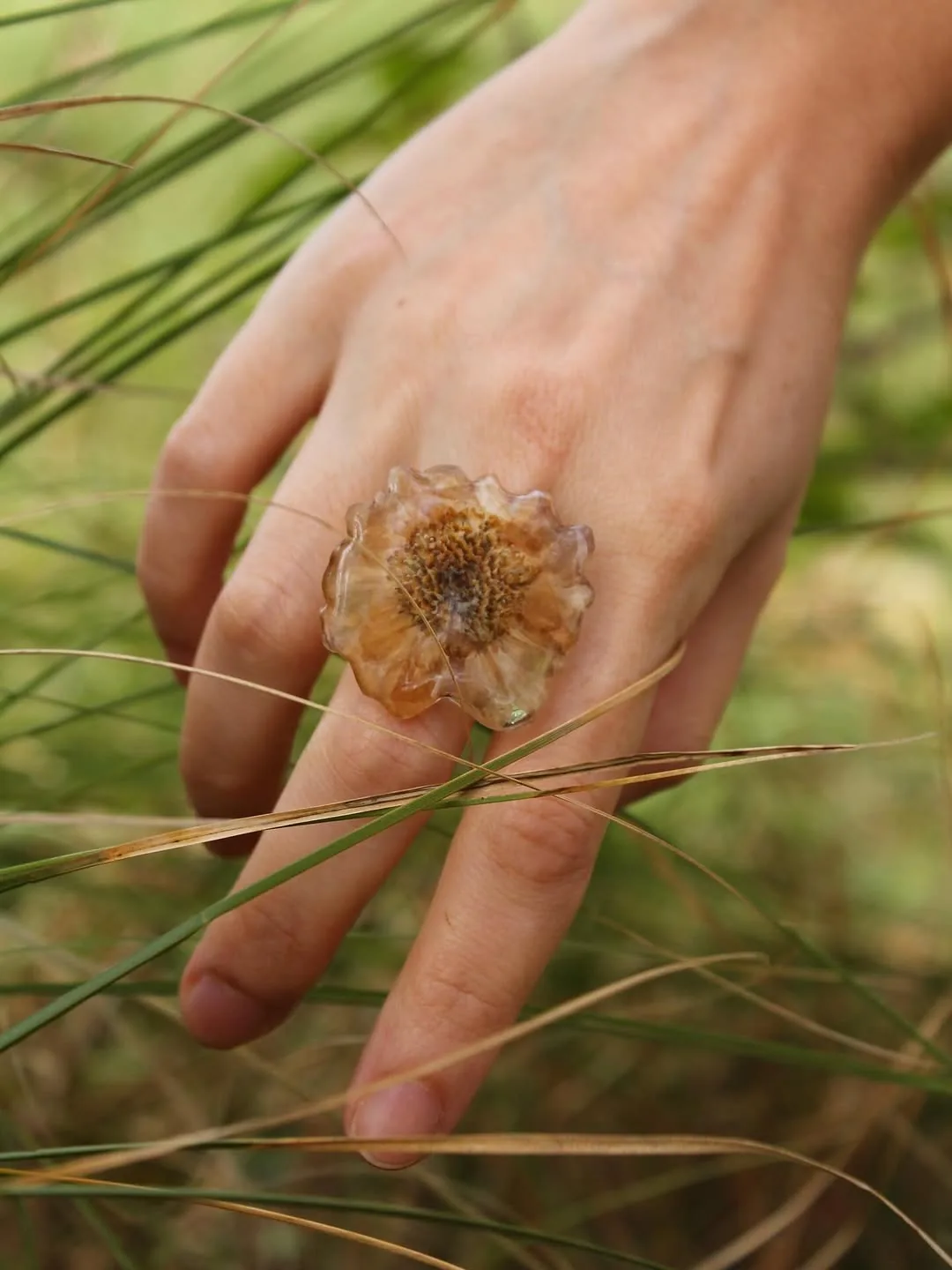 Anillo con una flor seca entera sobre una mano